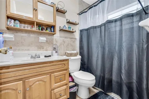 a bathroom with a sink a toilet and a shower curtain
