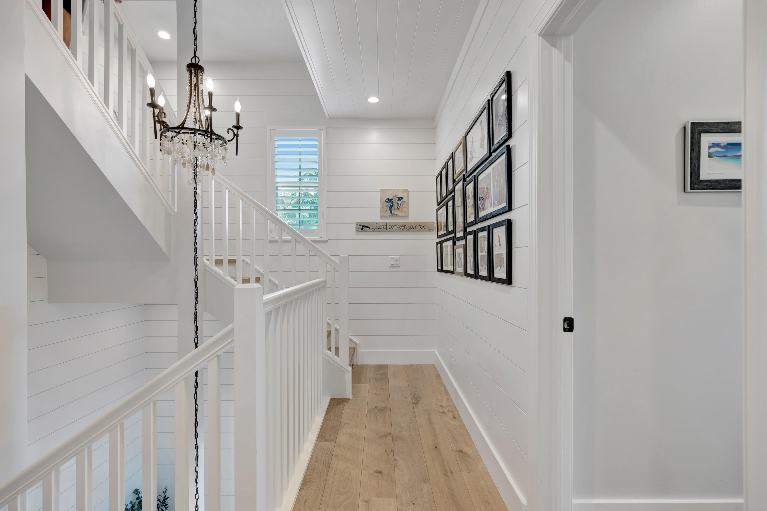 270 Mercury Road, Unit D Juno Beach, FL 33408 - Photo 43 of 107 a view of staircase with lots of frames on wall and wooden floor