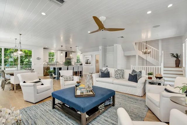 a large kitchen with stainless steel appliances kitchen island granite countertop a sink a counter space and a view of living room