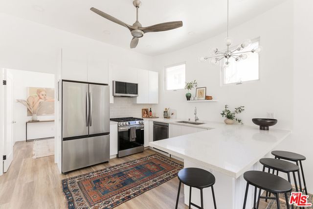 a kitchen with stainless steel appliances granite countertop a refrigerator and a stove top oven