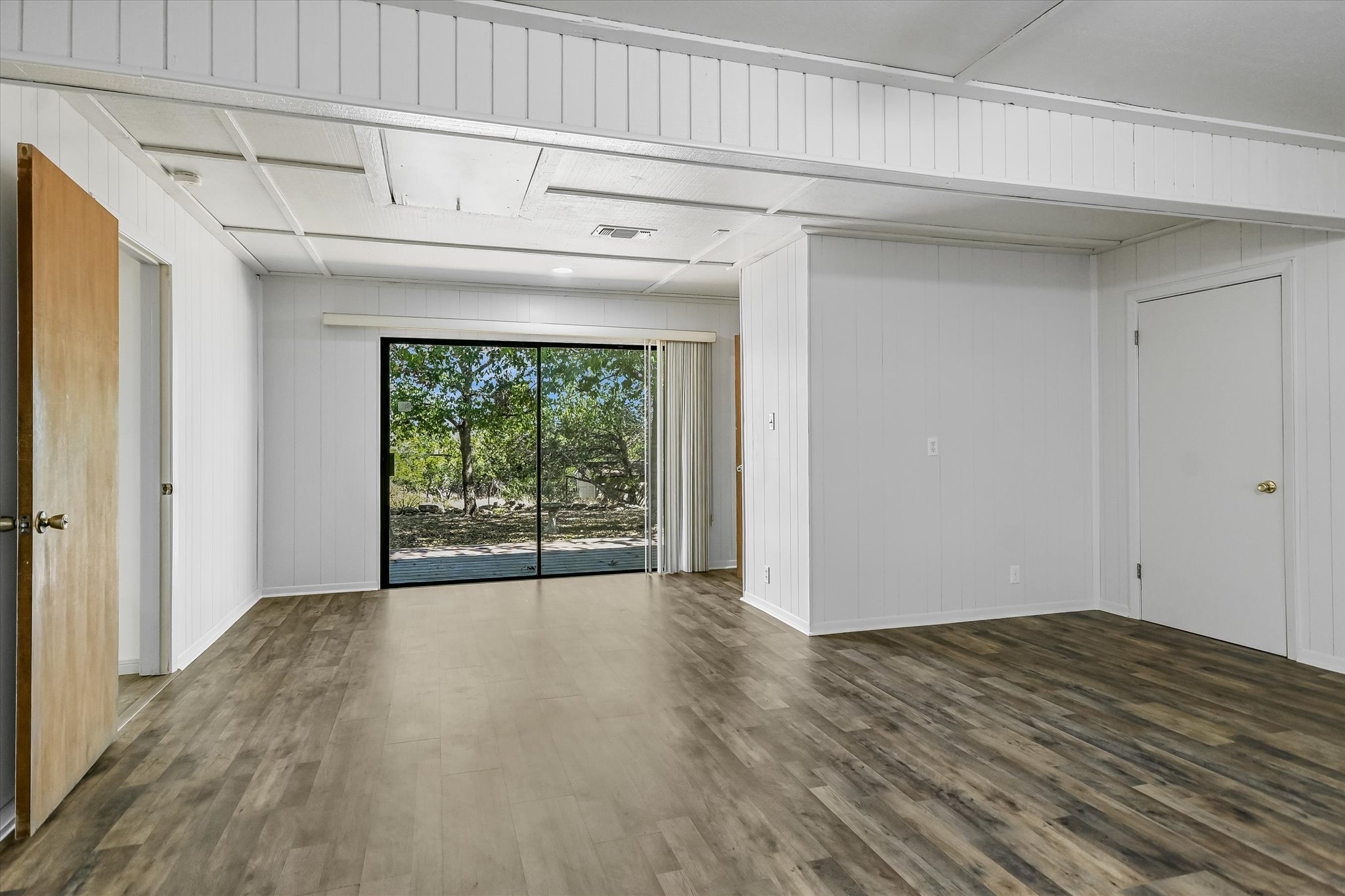 175 Fischer Trail Wimberley, TX 78676 - Photo 12 of 31 a view of an empty room with wooden floor and a window