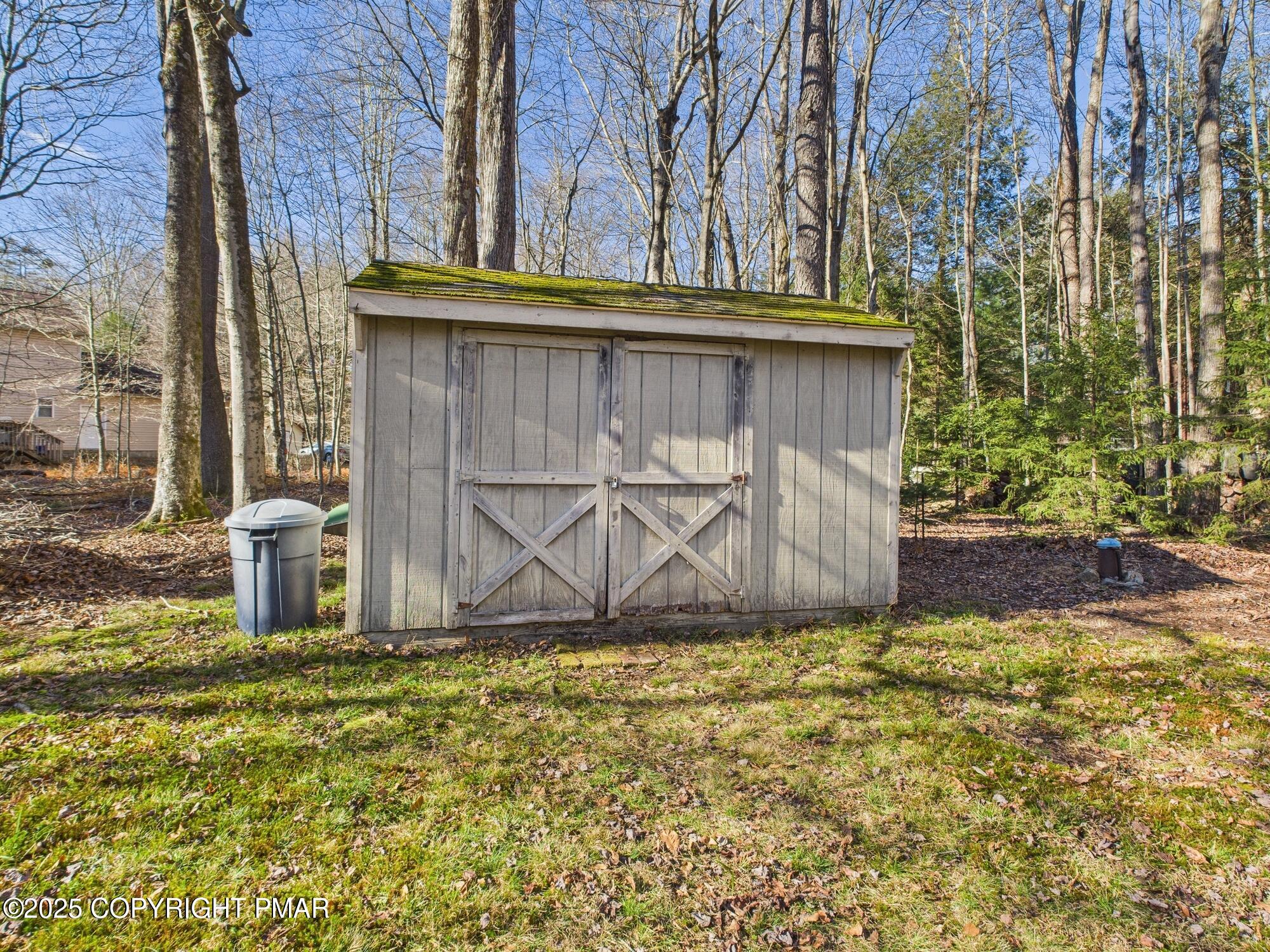 266 King Arthur Road Pocono Lake, PA 18347 - Photo 26 of 26 a view of a wooden house with large trees and a small yard