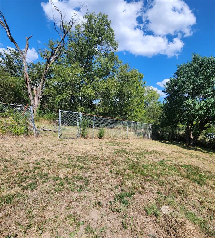 403 Barker Street Cumby, TX 75433 - Photo 14 of 16 Fenced property perimeter featuring a chain-link fence and gate