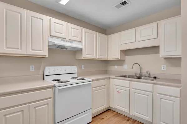 a kitchen with white cabinets and white appliances