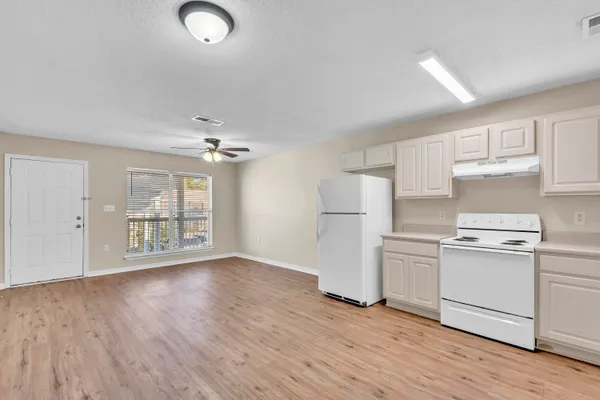 wooden floor in an empty room with a kitchen