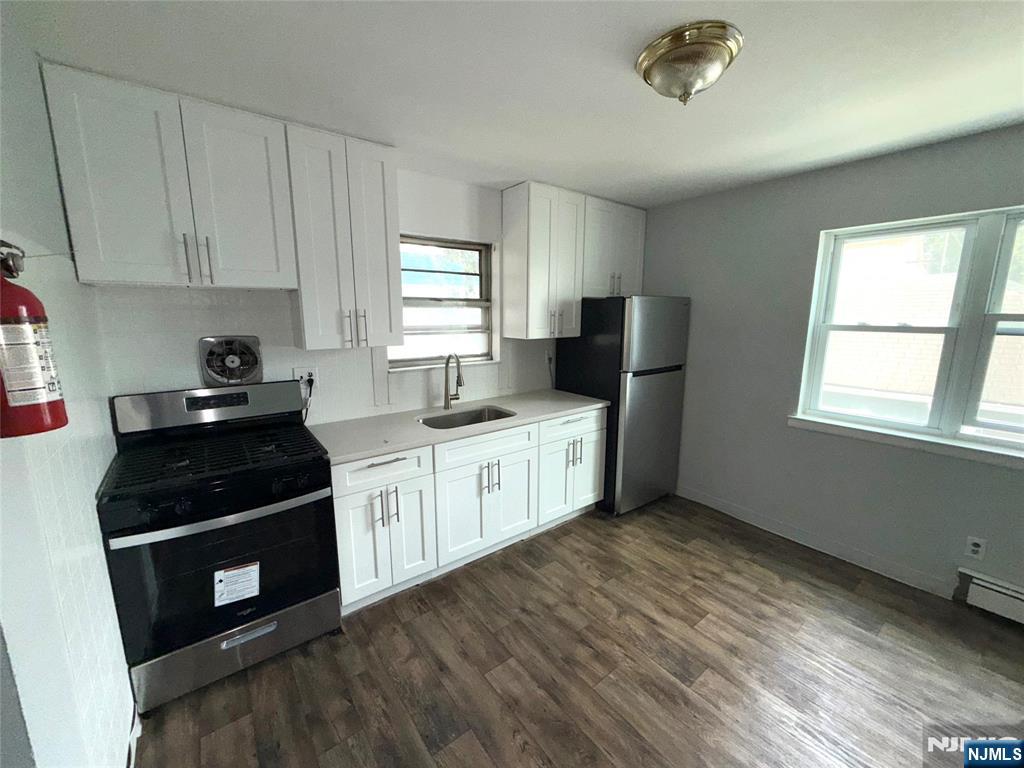 224-226 Clinton Street, Unit 224 Paterson, NJ 07522 - Photo 12 of 12 a kitchen with a stove a sink and a window