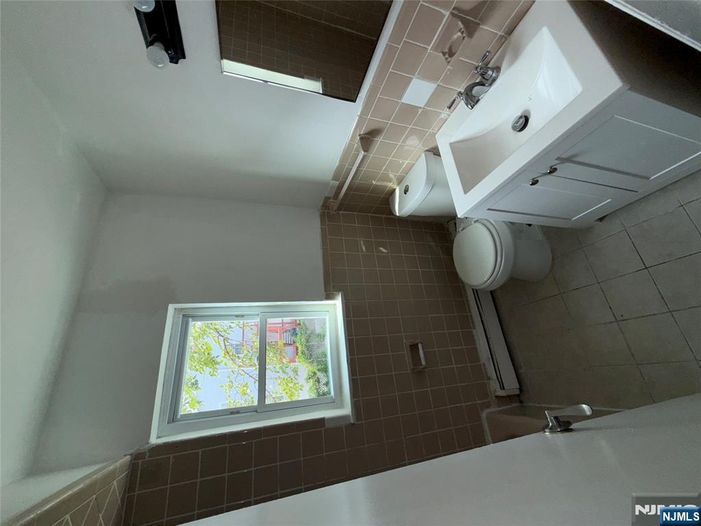 224-226 Clinton Street, Unit 224 Paterson, NJ 07522 - Photo 6 of 12 a white toilet sitting next to a bathroom sink