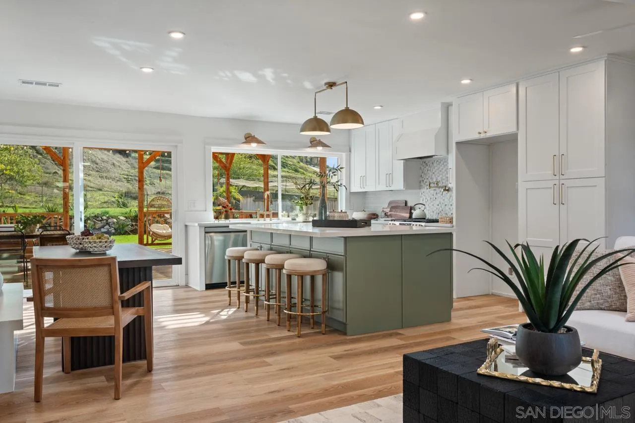1155 Pepper Drive El Cajon, CA 92021 - Photo 11 of 62 a kitchen with stainless steel appliances granite countertop a refrigerator a stove a sink dishwasher and a dining table with wooden floor