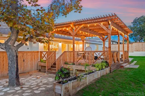 an aerial view of residential houses with outdoor space and trees