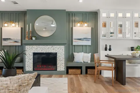 a living room with furniture kitchen view and a large window