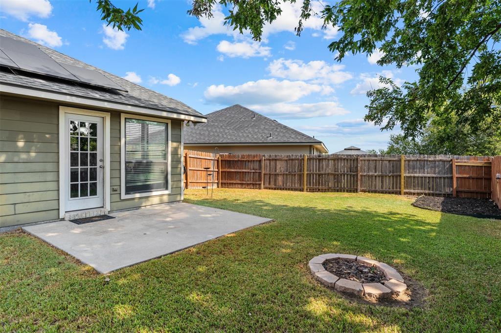10313 Condor Loop Waco, TX 76708 - Photo 33 of 33 Expansive backyard featuring a concrete patio, a built-in fire pit, and wood privacy fencing
