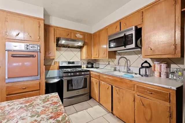 a kitchen with stainless steel appliances granite countertop a stove microwave and sink