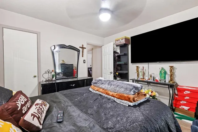 a spacious bedroom with a bed and a flat screen tv