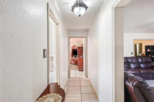 a view of a hallway with wooden floor and a livingroom
