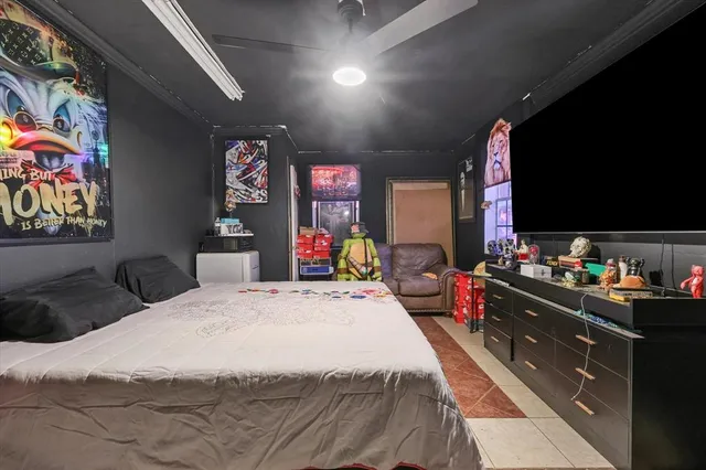 a bedroom with a bed a flat screen tv and wall paintings