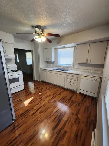 a kitchen with kitchen island white cabinets and stainless steel appliances