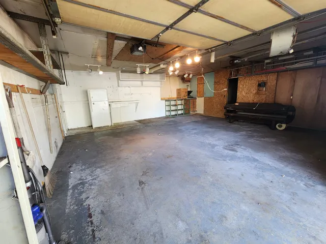a view of backyard with wooden fence and a large tree