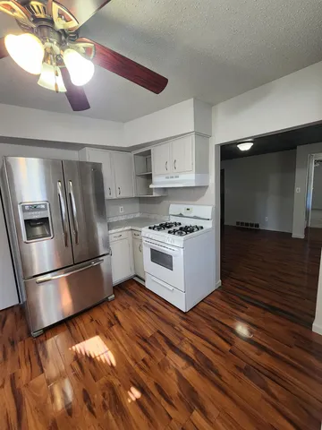 a kitchen with stainless steel appliances wooden floor sink and cabinets