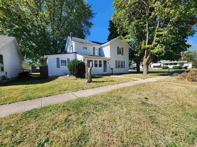 a view of a house with backyard and tree s