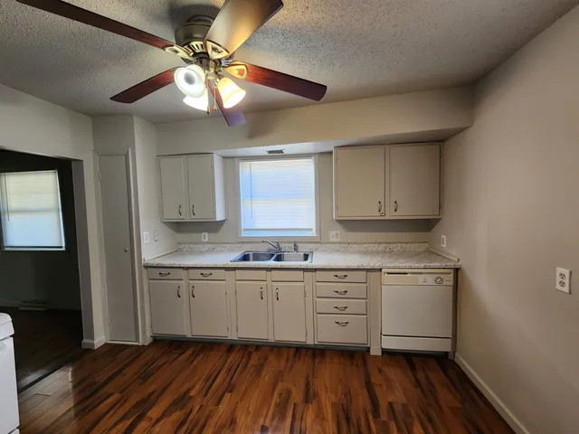 a kitchen with a sink cabinets and wooden floor