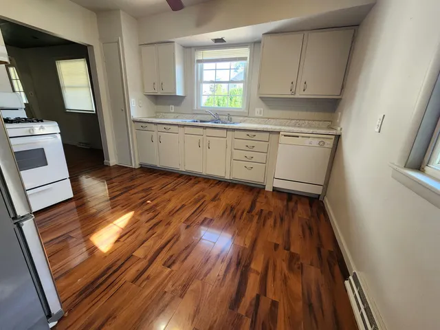 a kitchen with wooden floors and white appliances