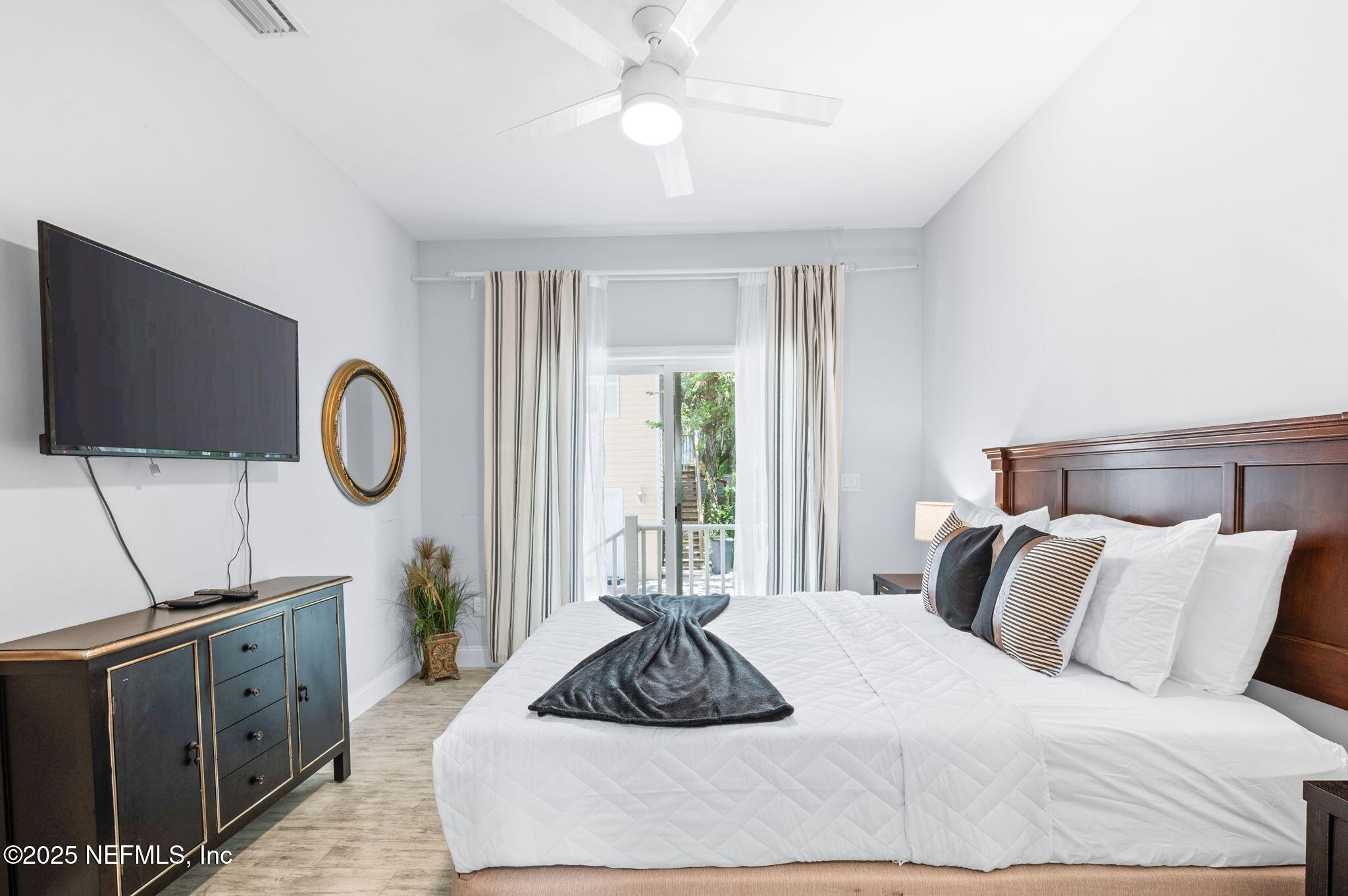 239 Riberia Street St. Augustine, FL 32084 - Photo 46 of 88 a bedroom with a large bed and a flat tv screen on dresser