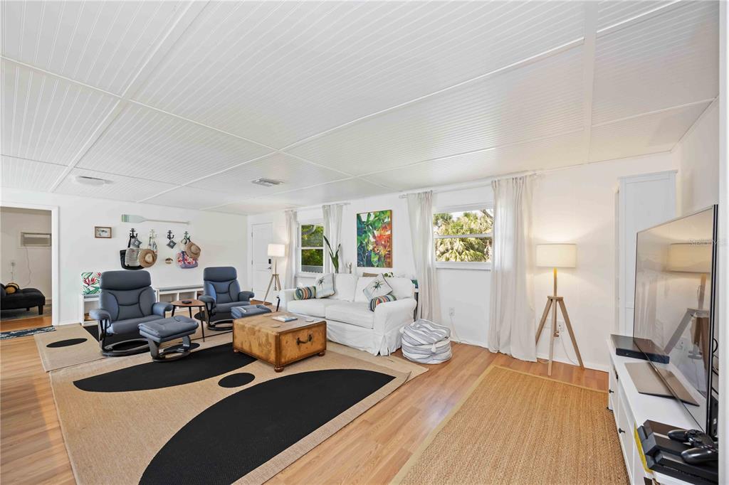 5075 North Beach Road, Unit B4 Englewood, FL 34223 - Photo 11 of 79 a living room with furniture a fireplace and a flat screen tv