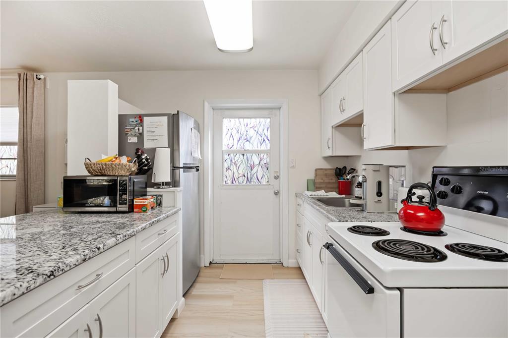 5075 North Beach Road, Unit B4 Englewood, FL 34223 - Photo 27 of 79 a kitchen with granite countertop a sink stove and cabinets