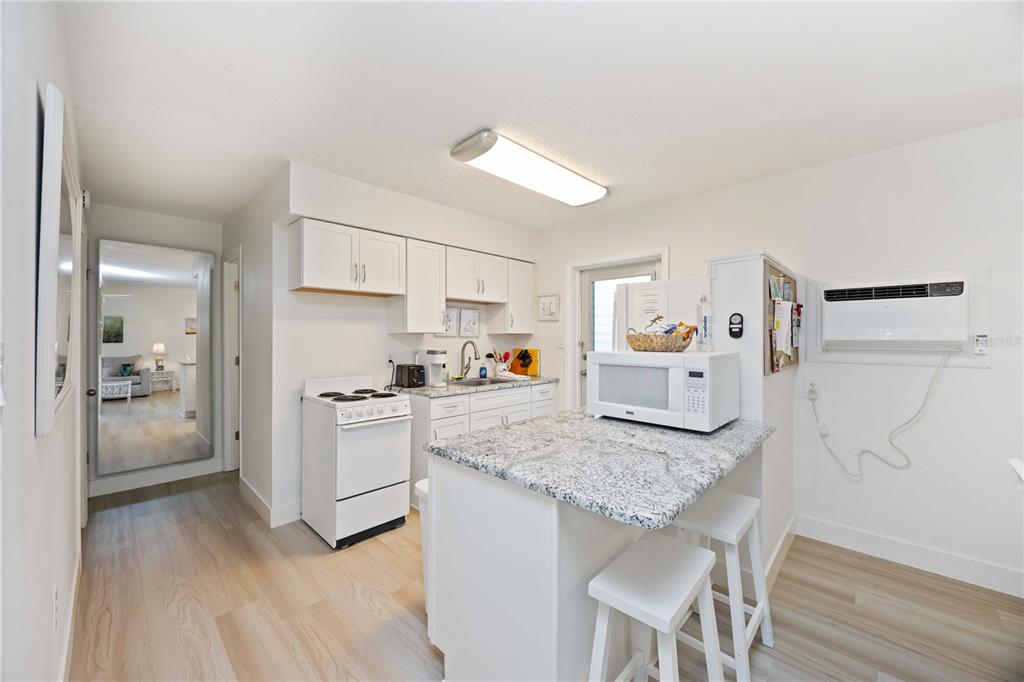 5075 North Beach Road, Unit B4 Englewood, FL 34223 - Photo 38 of 79 a kitchen with granite countertop cabinets and refrigerator