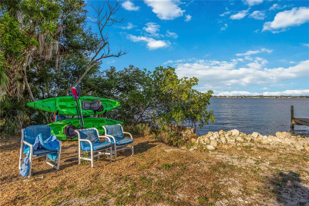 5075 North Beach Road, Unit B4 Englewood, FL 34223 - Photo 60 of 79 a backyard of a house with table and chairs