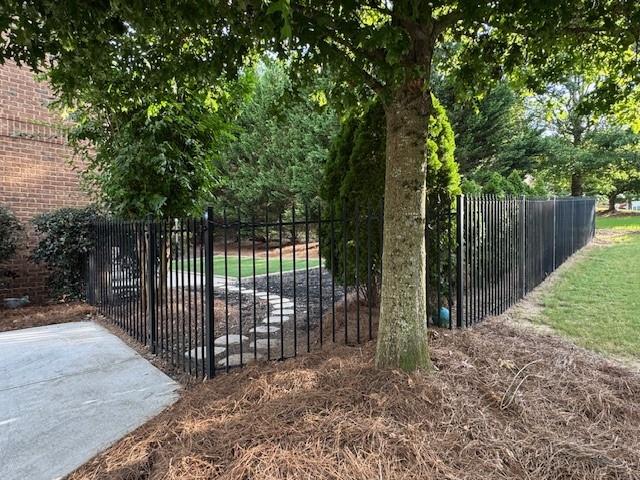 3715 Slater Street Cumming, GA 30041 - Photo 12 of 36 a view of a backyard with large trees and wooden fence