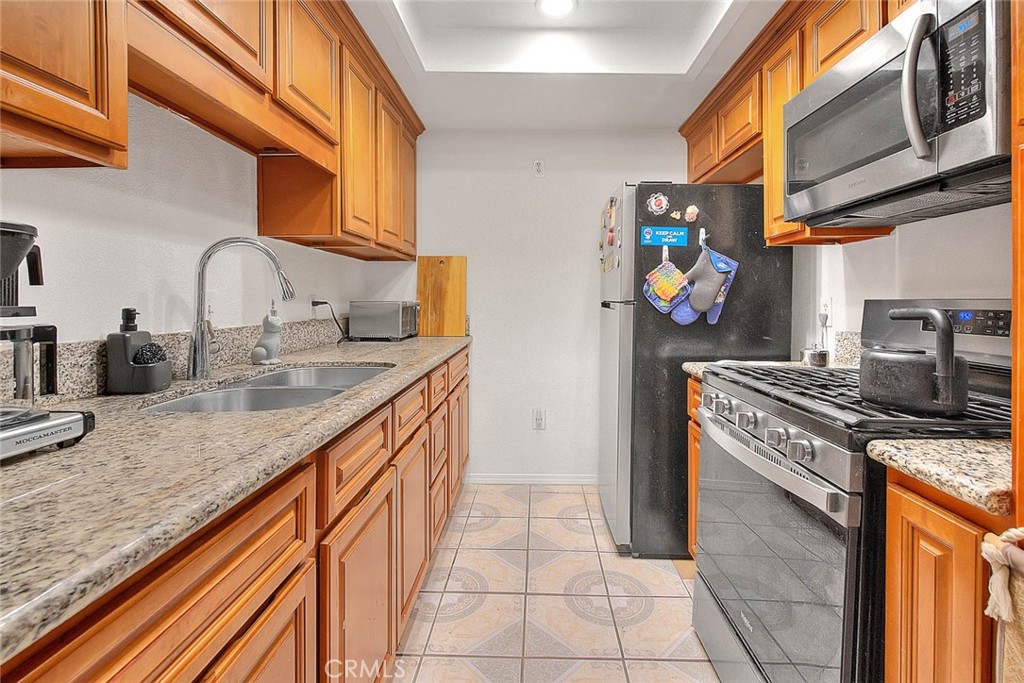 700 West 3rd Street, Unit A111 Santa Ana, CA 92701 - Photo 3 of 15 a kitchen with stainless steel appliances granite countertop a sink and cabinets