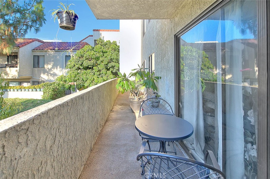 700 West 3rd Street, Unit A111 Santa Ana, CA 92701 - Photo 9 of 15 a balcony with table and chairs and potted plants