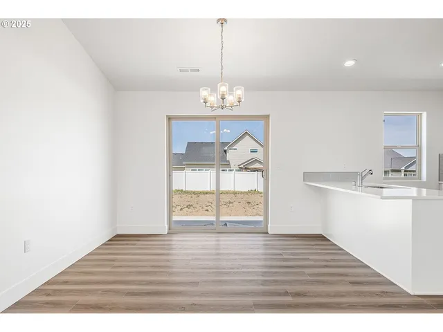 a view of wooden floor and a chandelier in a room