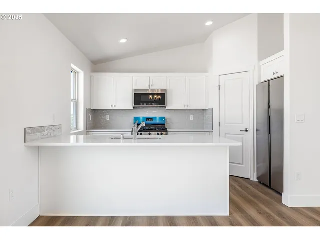 a kitchen with kitchen island a sink stainless steel appliances and white cabinets