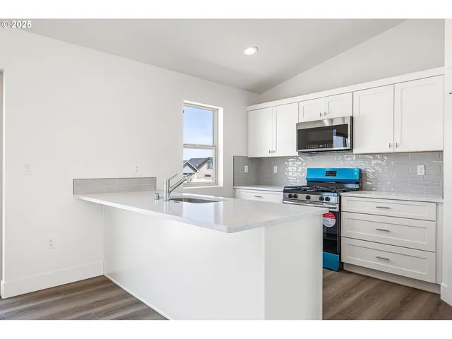 a kitchen with kitchen island a sink stainless steel appliances and cabinets