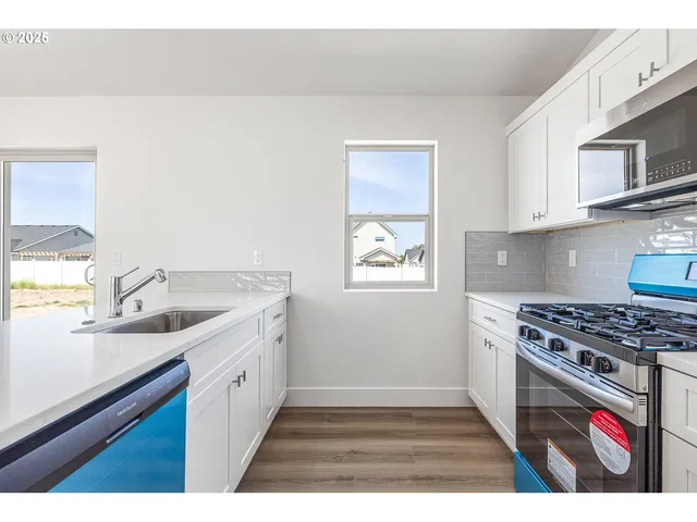 a kitchen with stainless steel appliances granite countertop a stove a sink and a microwave