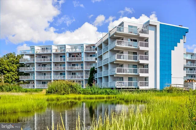 a front view of a residential apartment building with a yard