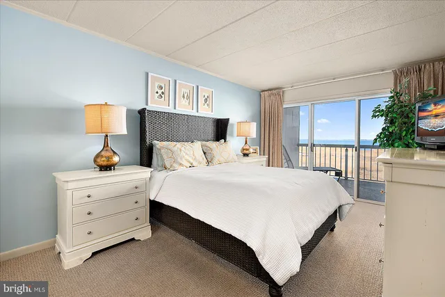 a bedroom with a bed and a lamp on dresser