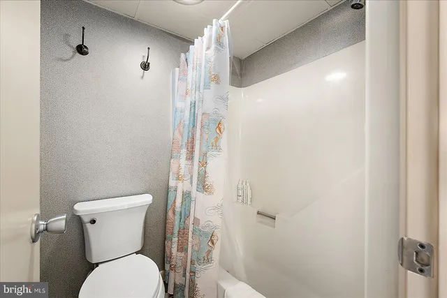 a white toilet sitting next to a shower