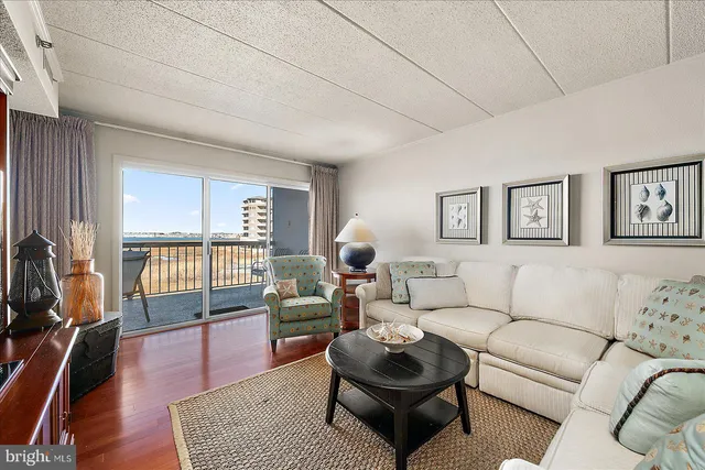 a living room with furniture a rug a lamp and a window