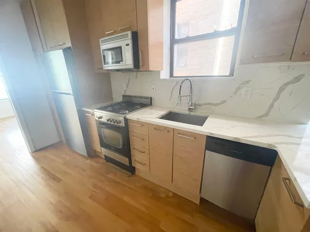 a kitchen with a stove a sink and a window