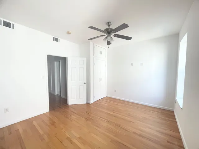 a view of empty room with wooden floor
