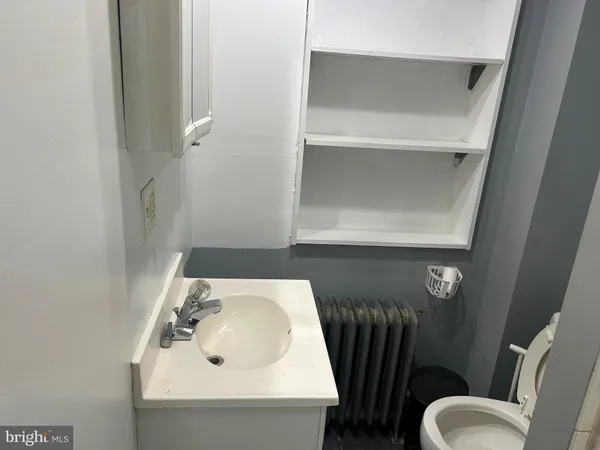 a bathroom with a toilet sink and mirror
