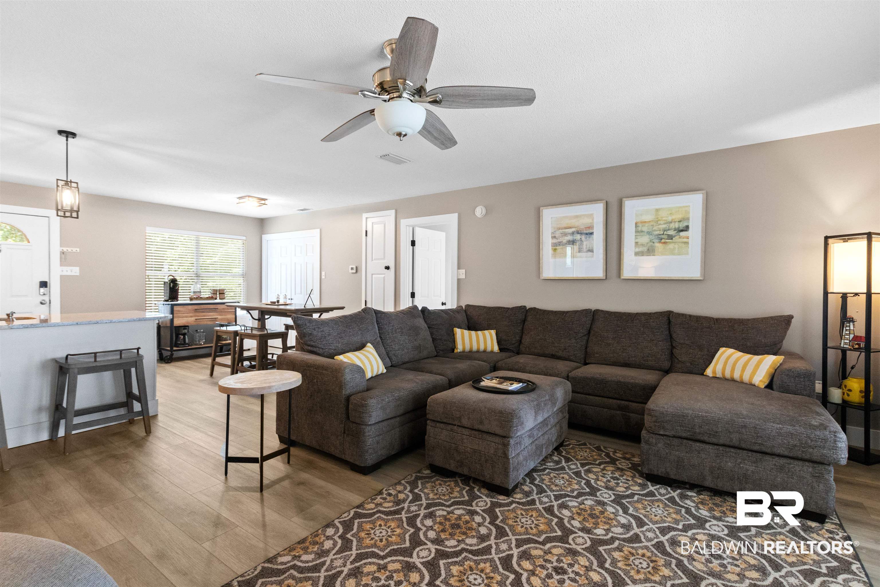 9581 South Bay Street Foley, AL 36535 - Photo 11 of 44 Open-concept living space featuring wood-finish flooring, a ceiling fan with integrated lighting, and neutral wall tones