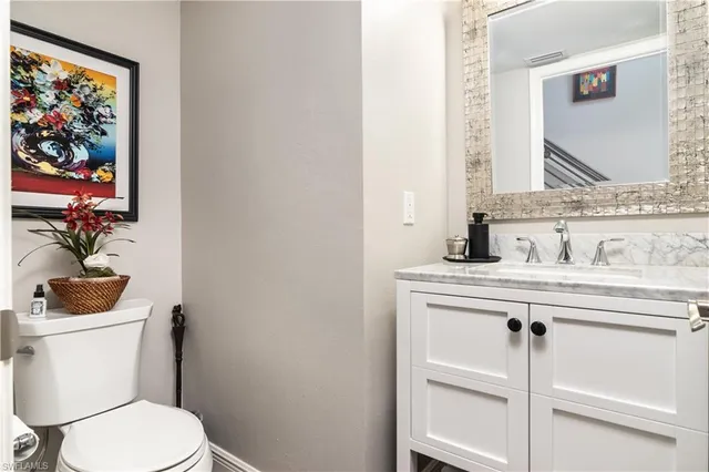 a bathroom with a toilet a sink and mirror