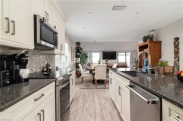 a kitchen with stainless steel appliances granite countertop lots of counter space a sink and cabinets