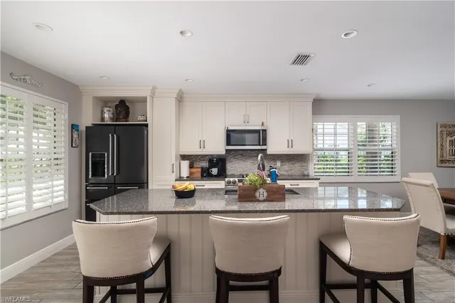 a kitchen with a dining table chairs and refrigerator
