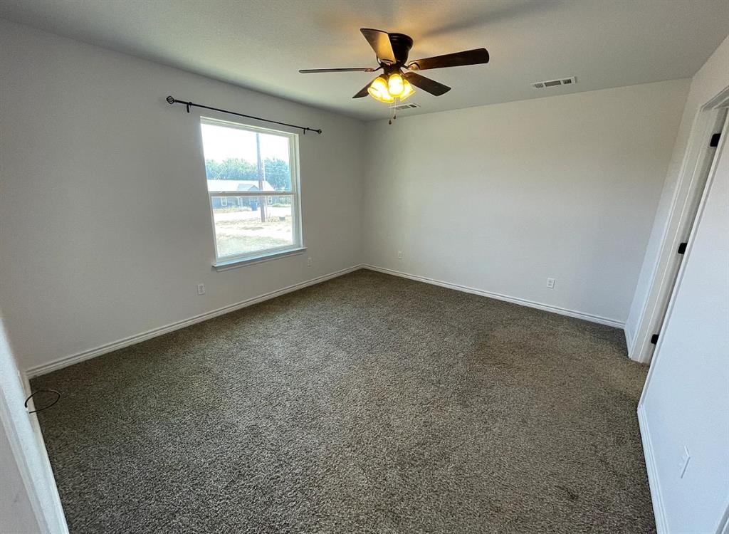 109 Spruce Tree Court Poolville, TX 76487 - Photo 14 of 21 an empty room with windows and fan
