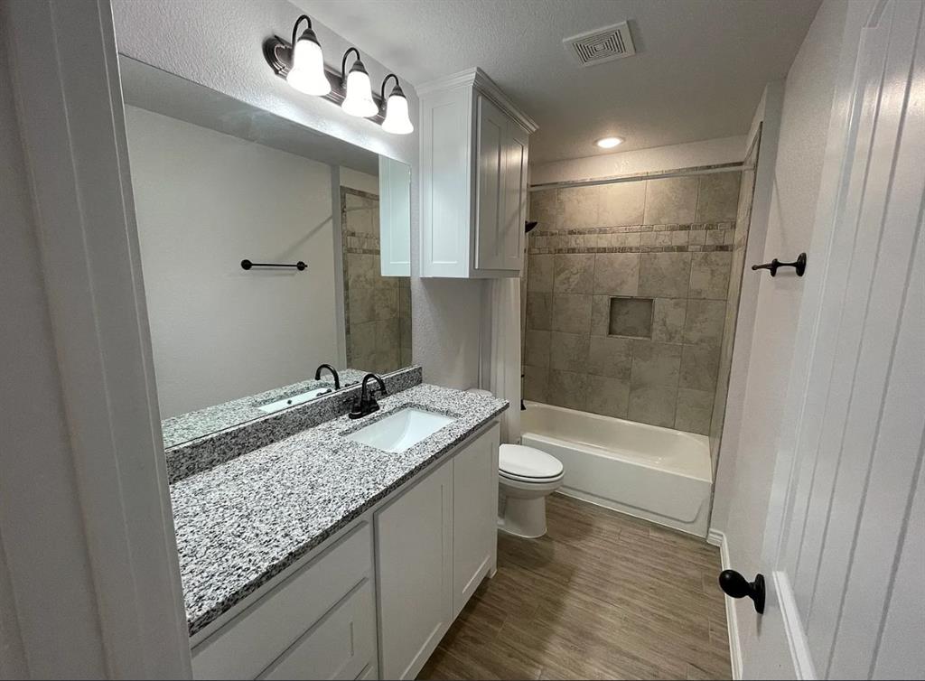 109 Spruce Tree Court Poolville, TX 76487 - Photo 16 of 21 a bathroom with a granite countertop sink mirror vanity and toilet